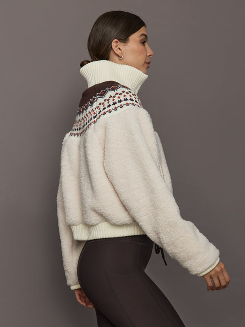 Fairisle Sherpa Jacket in nude sherpa with ribbed cuffs and Fairisle knit detail, side view.