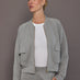 Model is wearing a heather grey Ultrasoft Bomber Jacket with front zip closure and utility pockets, front view.