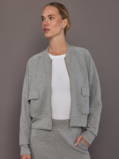 Model is wearing a heather grey Ultrasoft Bomber Jacket with front zip closure and utility pockets, front view.
