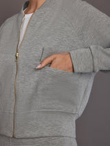 Close-up of the heather grey Ultrasoft Bomber Jacket showing gold zipper and front utility pocket detail.