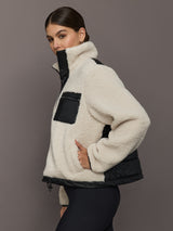 Sherpa jacket in natural cream with black faux leather chest pocket and trim, side view.