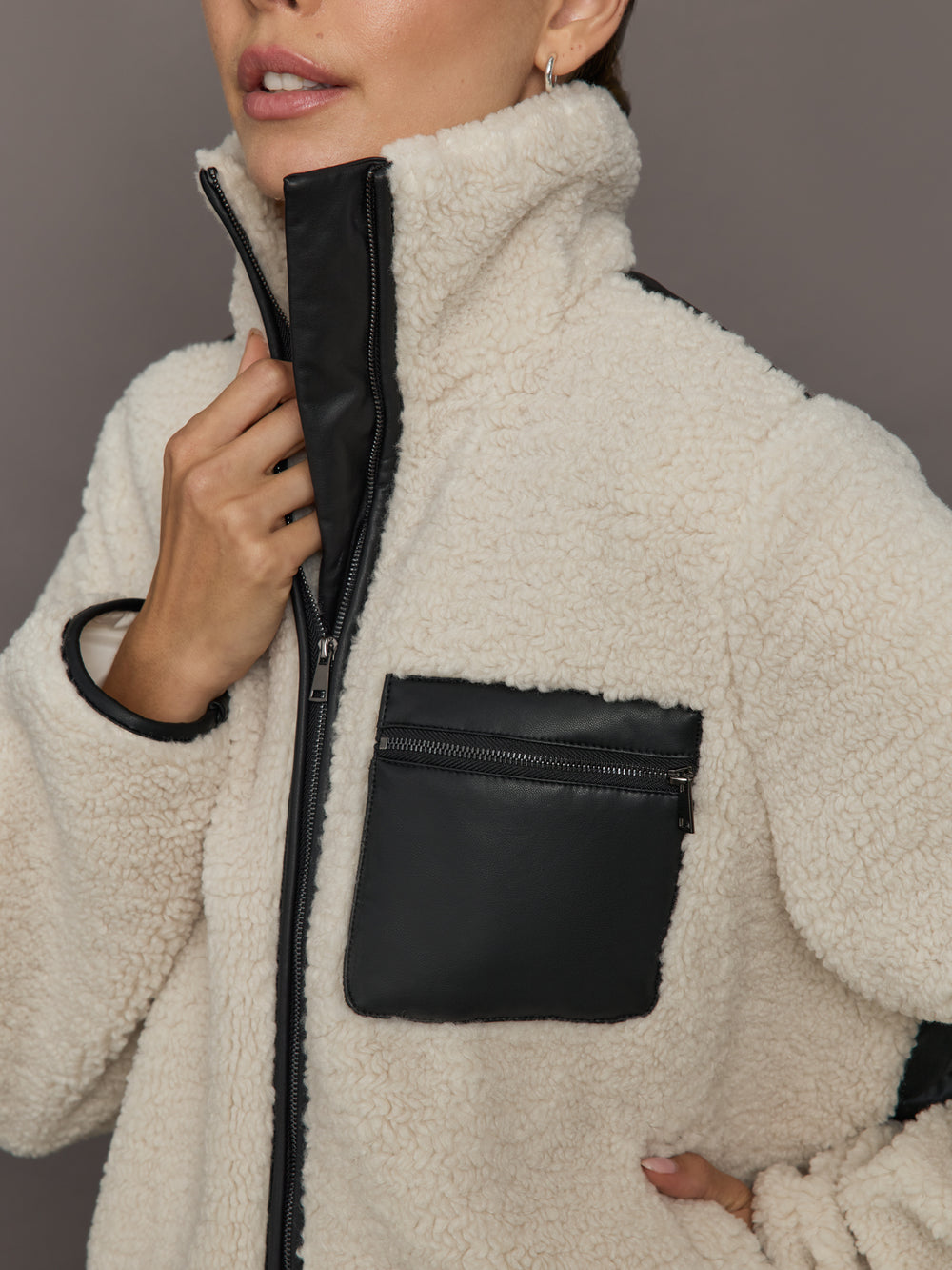 Close-up of Faux Leather Sherpa Jacket showing zippered faux leather chest pocket and sherpa texture.