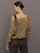 Model wears a crocheted one shoulder sweater in light brown.