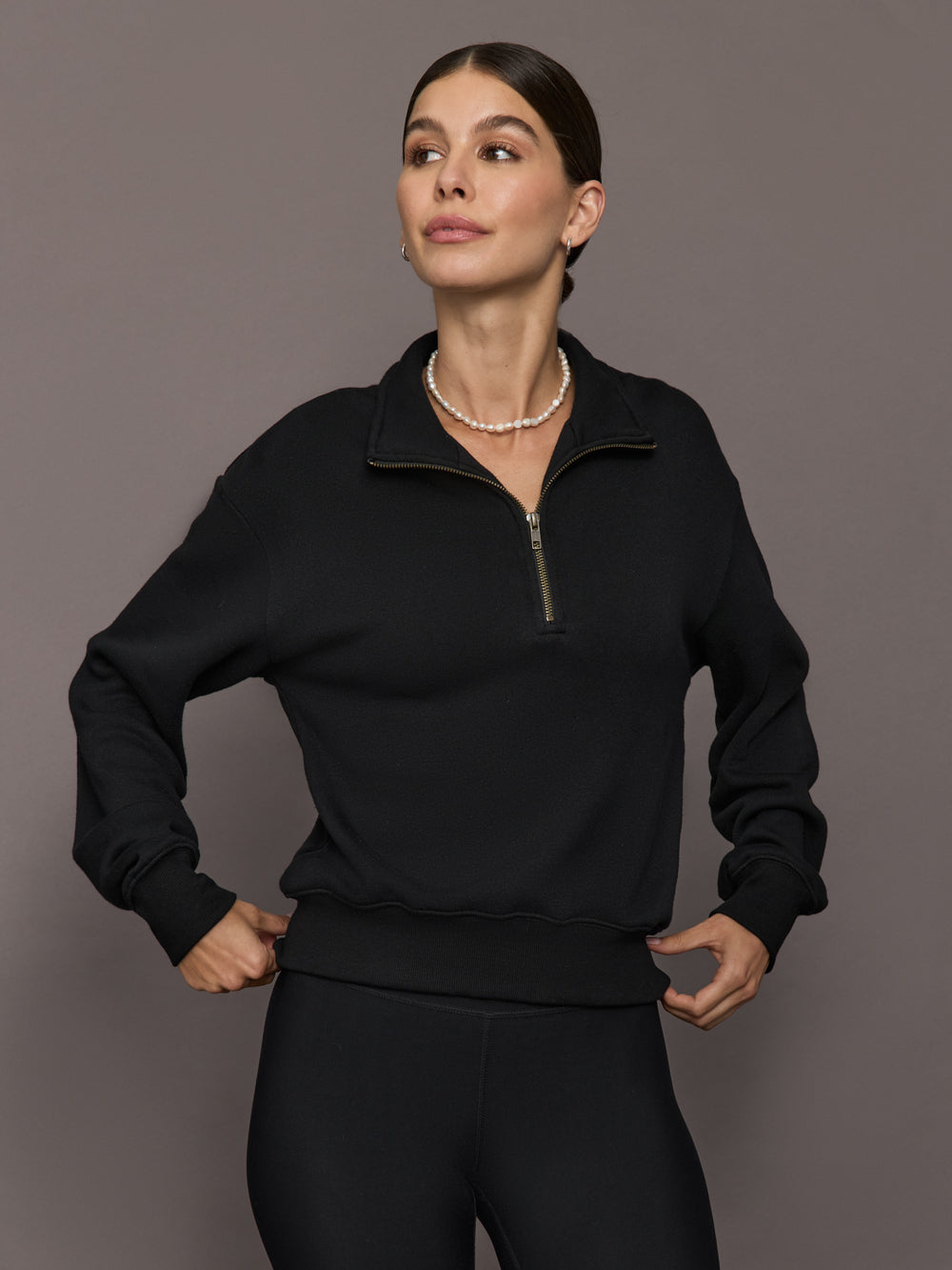 Model is wearing the Half Zip Fleece Top in black with stand collar and front half-zip closure, front view.