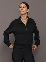 Model is wearing the Half Zip Fleece Top in black with stand collar and front half-zip closure, front view.