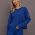 Model is wearing French terry crew neck sweatshirt in cobalt, front view.
