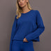 Model is wearing French terry crew neck sweatshirt in cobalt, front view.