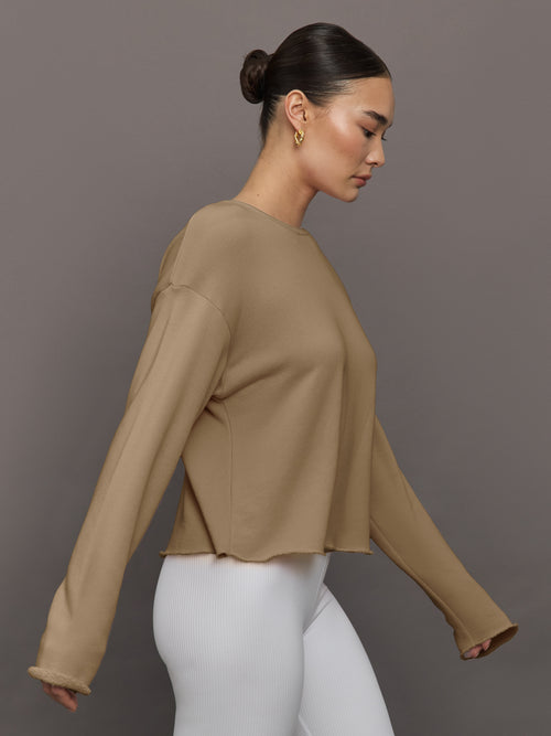 Side view of model in Crew Neck Sweatshirt in French Terry Chinchilla with relaxed fit.