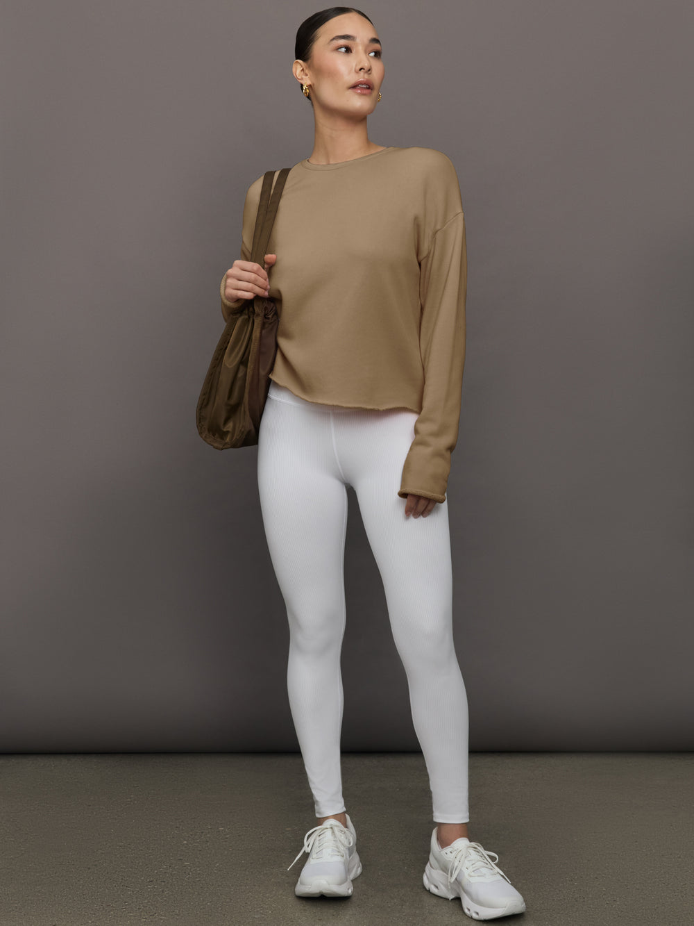 Full body view of model in Crew Neck Sweatshirt in French Terry Chinchilla styled with white leggings and sneakers.