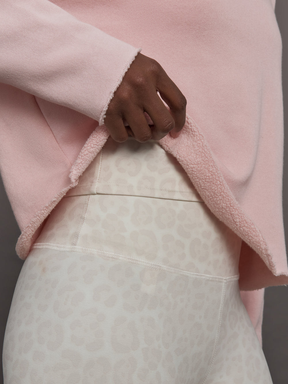 Close-up detail of lotus French Terry sweatshirt raw hem and fabric texture.