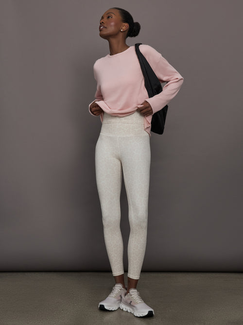 Model styled in lotus French Terry crew neck sweatshirt with leggings and sneakers, full body view.