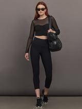 Model wears the The Melt and Mesh Ruched Top in Black, with a ruched center front, mesh on the sleeves and upper chest, and is cropped.