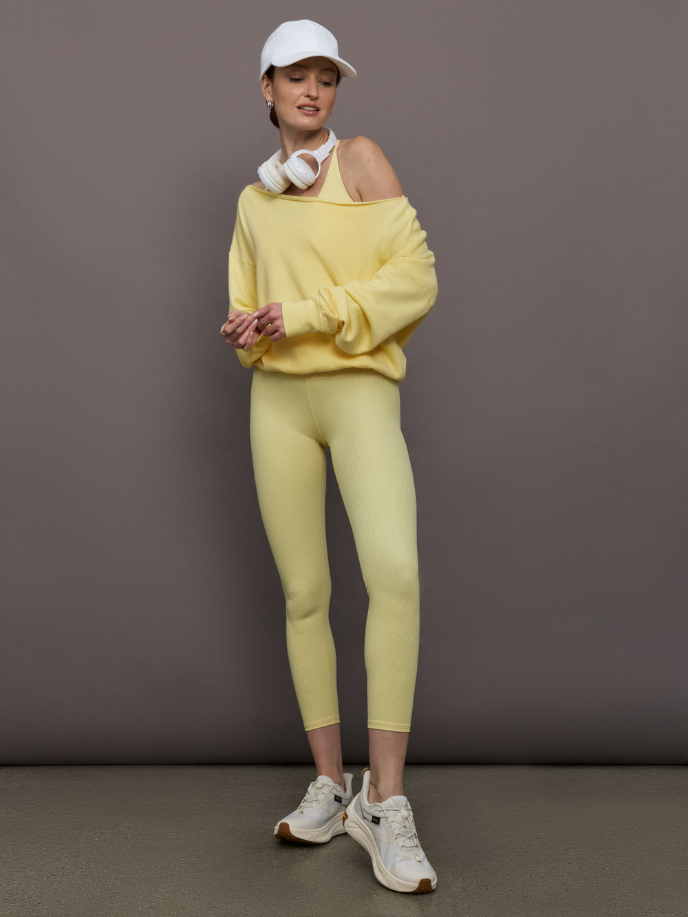 Model is wearing the French Terry Off-Shoulder Sweatshirt in Banana, full body view styled with matching leggings.