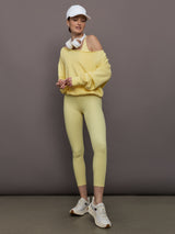 Model is wearing the French Terry Off-Shoulder Sweatshirt in Banana, full body view styled with matching leggings.