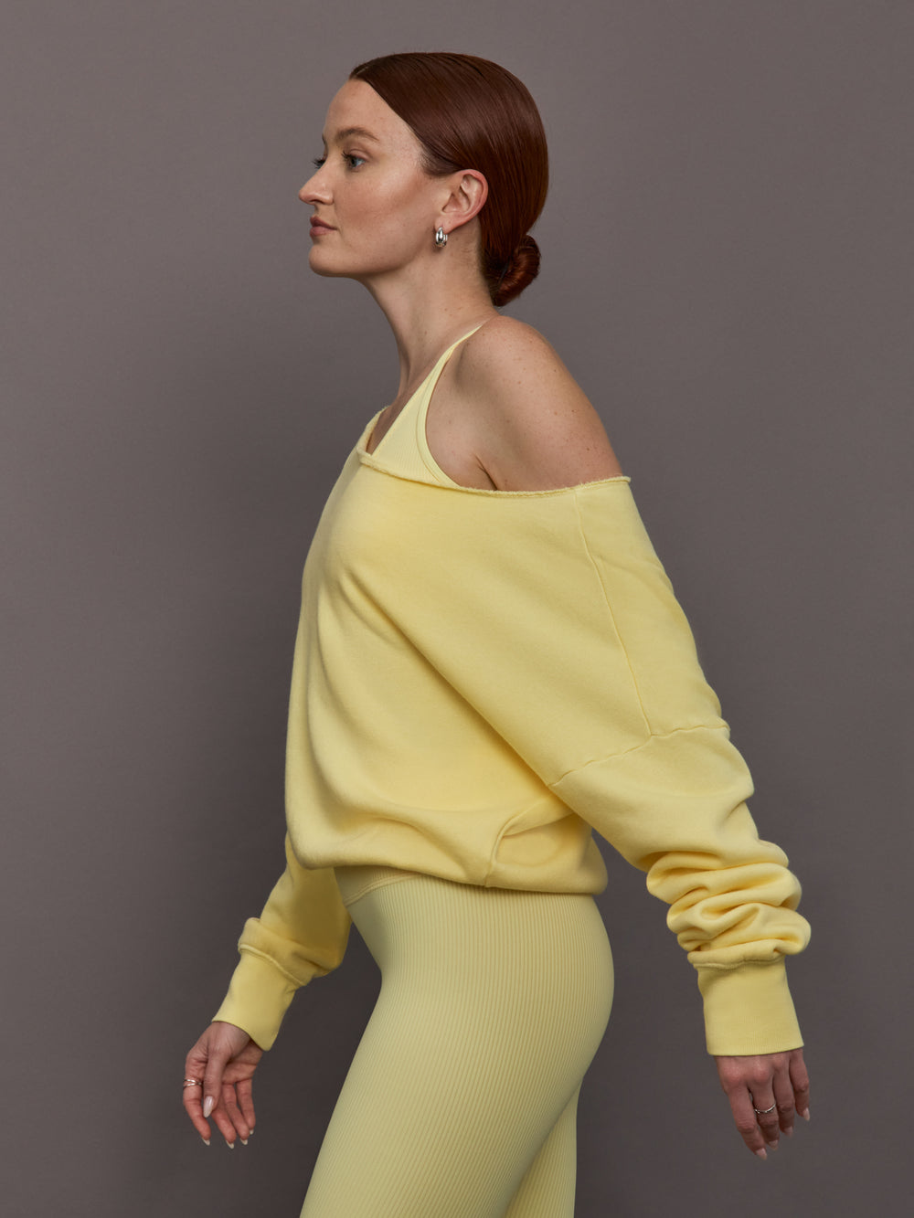 Model is wearing the French Terry Off-Shoulder Sweatshirt in Banana, side profile view.