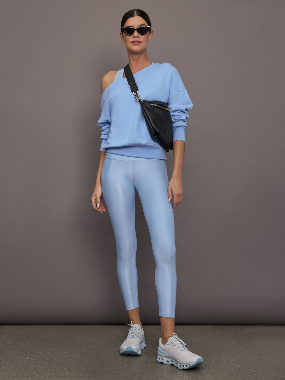 Model is wearing the High Rise 7/8 Legging in Takara Shine in Serenity styled with a sweatshirt and sneakers.