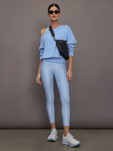 Model is wearing the High Rise 7/8 Legging in Takara Shine in Serenity styled with a sweatshirt and sneakers.