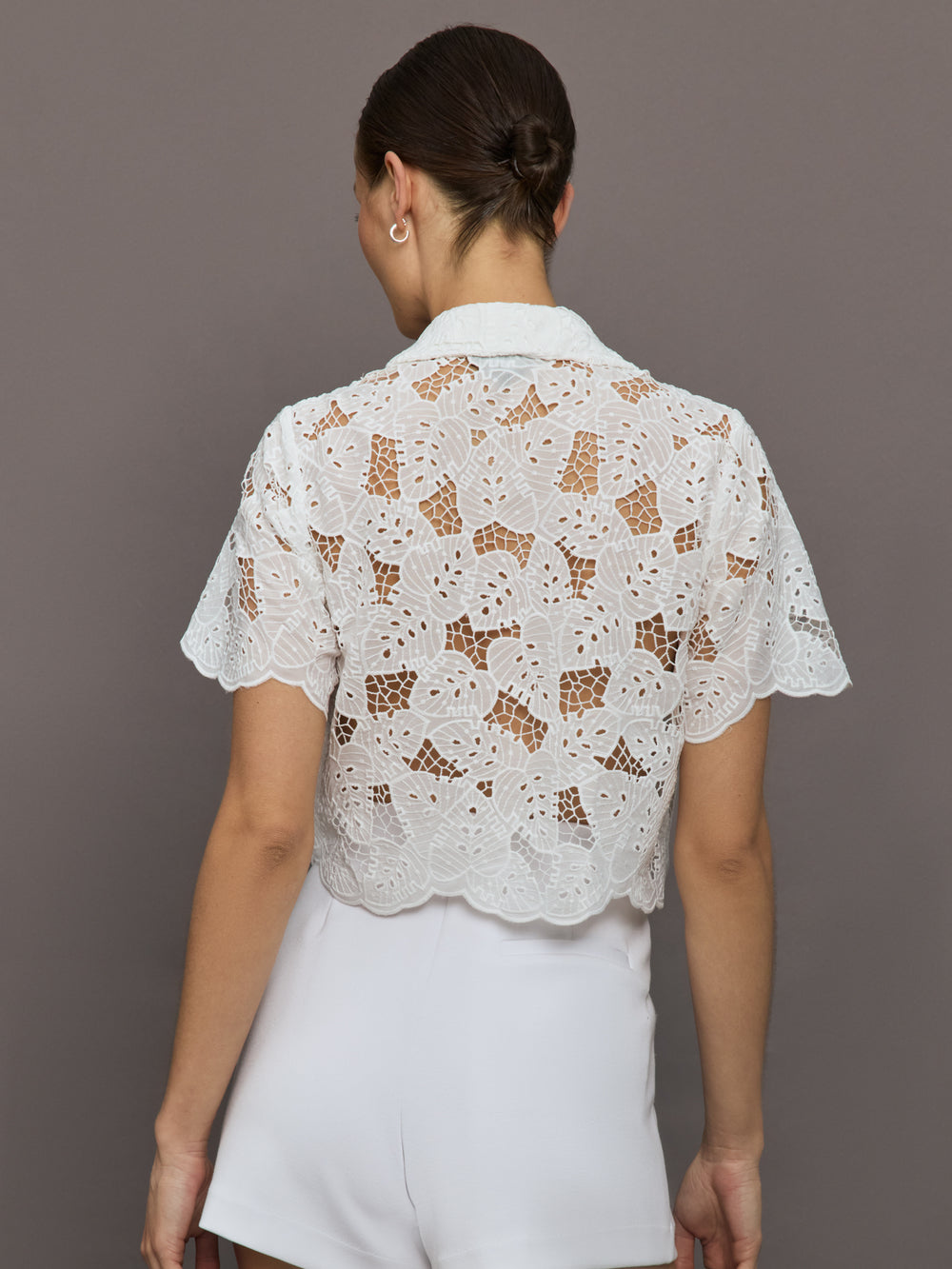 Model wears cropped Resort Shirt with button up front, a relaxed fit, and leaf embroidery detailing.
