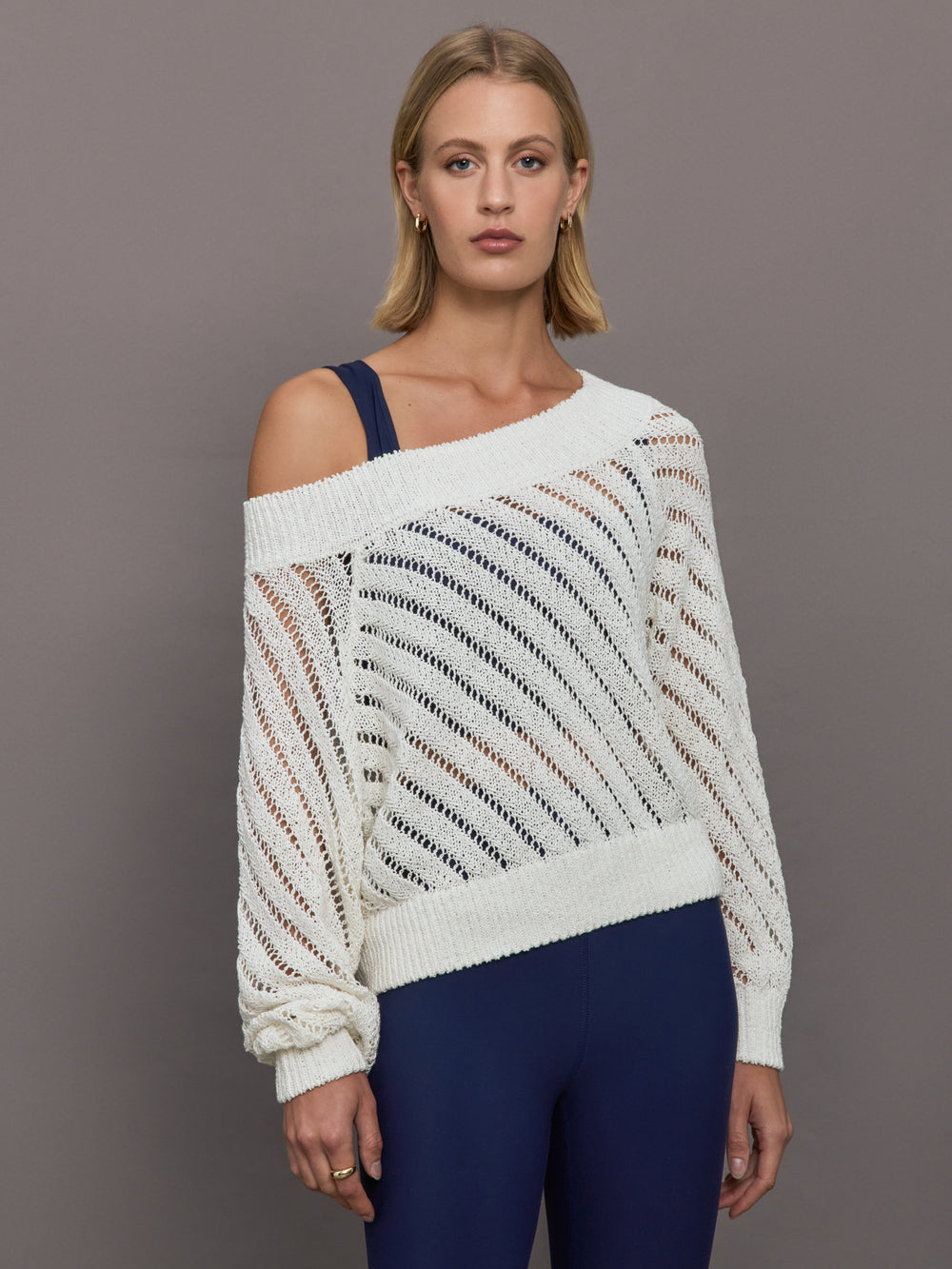 Model wears a white off shoulder mesh cardigan with diagonal pattern.  