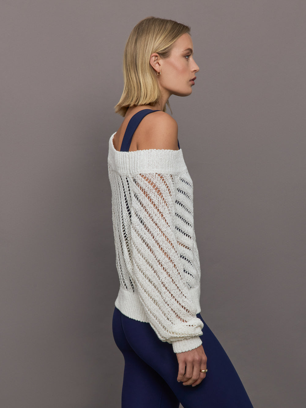 Model wears a white off shoulder mesh cardigan with diagonal pattern.  