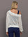 Model wears a white off shoulder mesh cardigan with diagonal pattern.  