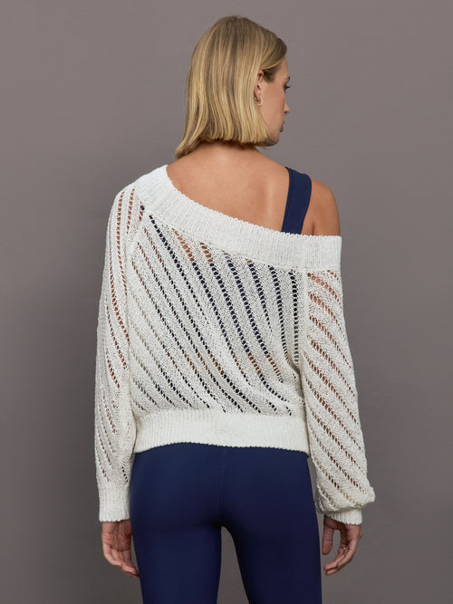 Model wears a white off shoulder mesh cardigan with diagonal pattern.  