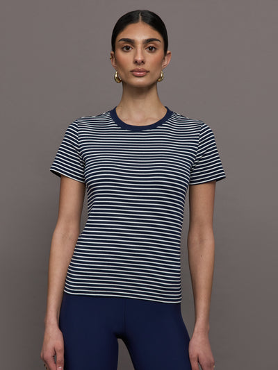 Model wears a navy and white horizontal striped short sleeve ringer tee. 