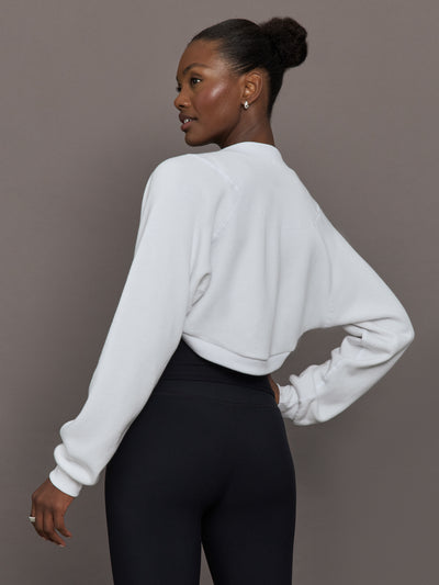 Model wearing fleece white long sleeve shrug.