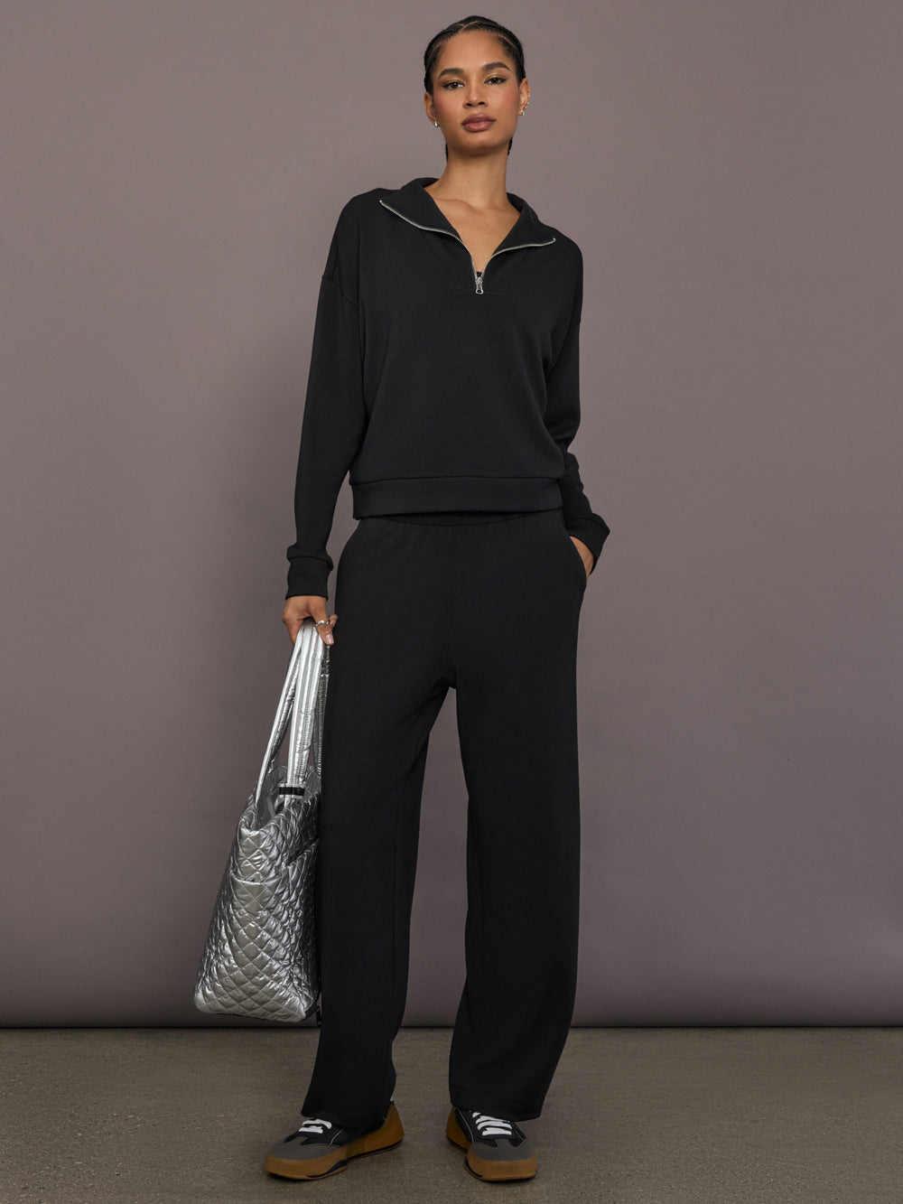 Model is wearing Interlock half zip pullover in black, full body front view.