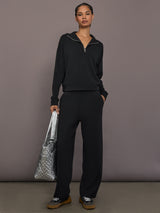 Model is wearing Interlock half zip pullover in black, full body front view.