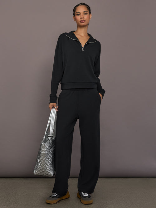 Model is wearing Interlock half zip pullover in black, full body front view.