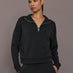 Model is wearing Interlock half zip pullover in black, close-up front view.