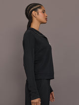 Model is wearing Interlock half zip pullover in black, side profile view.