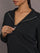 Model is wearing Interlock half zip pullover in black, close-up zipper detail.