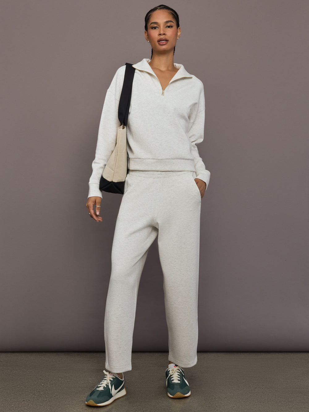 Model is wearing Interlock half zip pullover in Moonbeam Heather, full body front view.