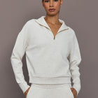 Model is wearing Interlock half zip pullover in Moonbeam Heather, front torso view.