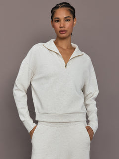 Model is wearing Interlock half zip pullover in Moonbeam Heather, front torso view.