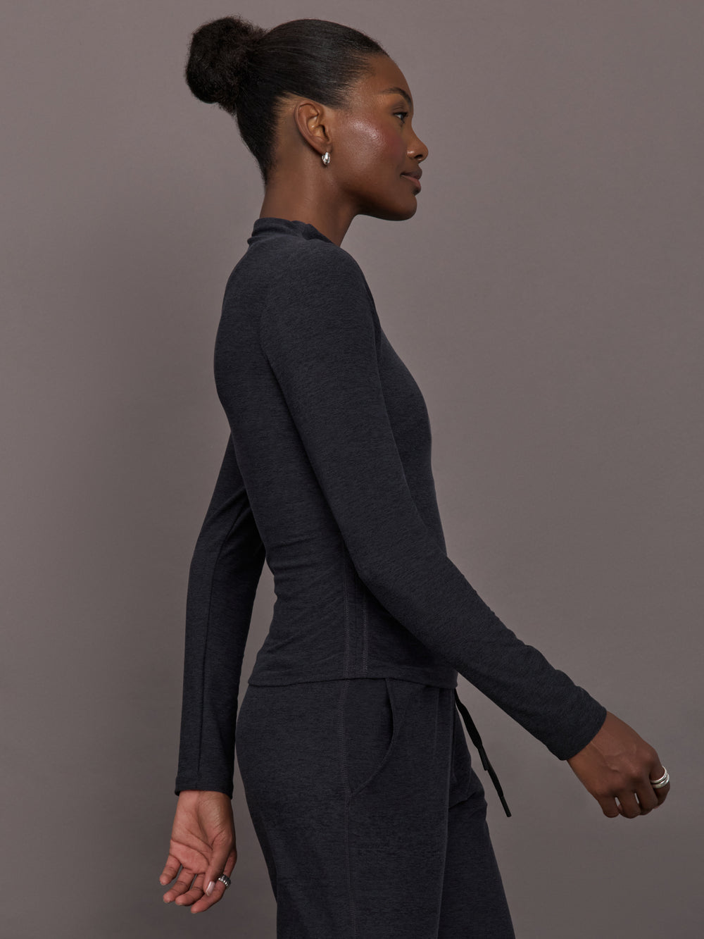 Model wears a mock neck long sleeve athletic top with extremely soft texture. 
