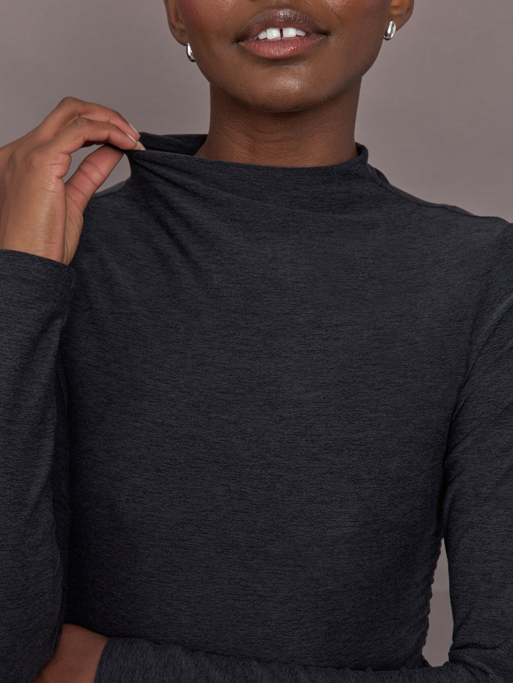 Model wears a mock neck long sleeve athletic top with extremely soft texture. 