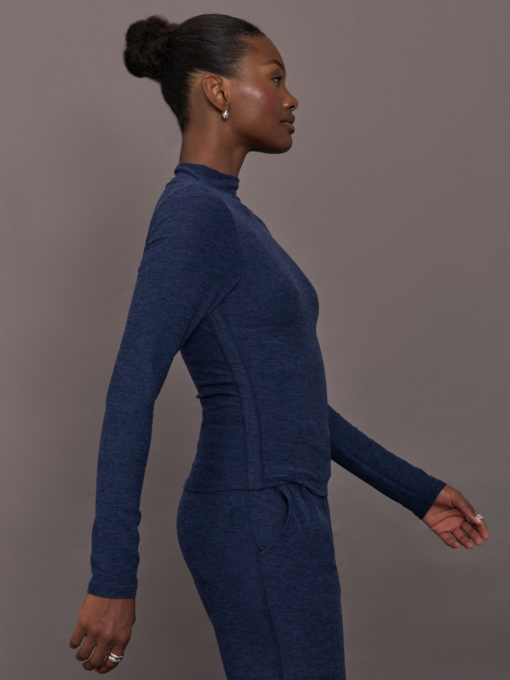 Model wears a long sleeve mock neck navy heather athletic wear top. 