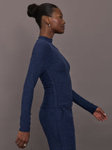 Model wears a long sleeve mock neck navy heather athletic wear top. 
