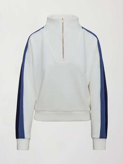 Model wearing an ivory half zip sweatshirt with blue accents.