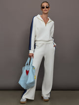 Model wearing an ivory half zip sweatshirt with blue accents.