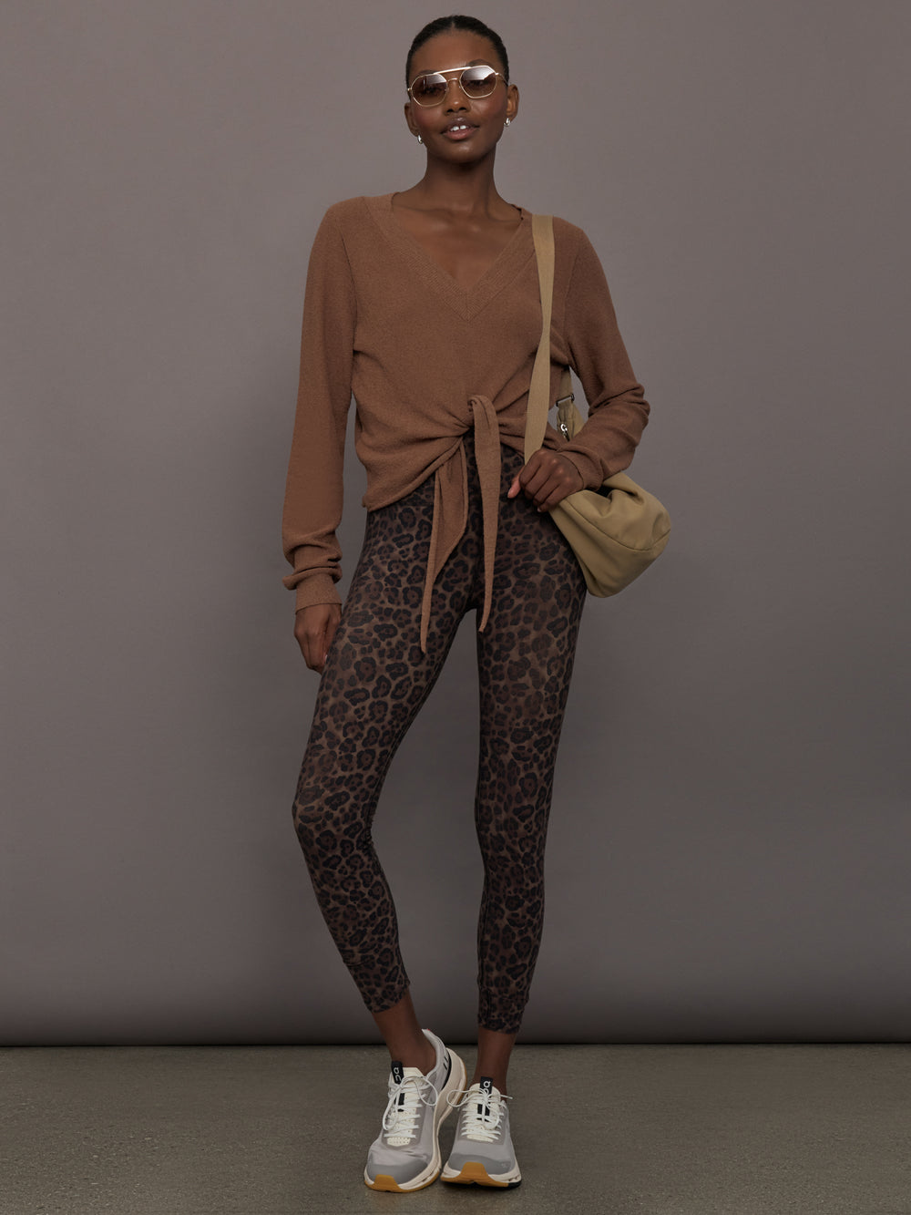 Model wearing a brown long-sleeve sweater with a knot detail 