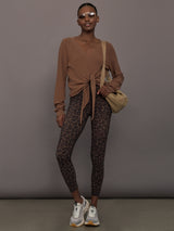 Model wearing a brown long-sleeve sweater with a knot detail 