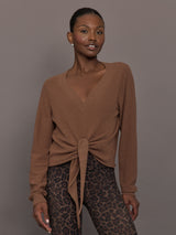Model wearing a brown long-sleeve sweater with a knot detail 
