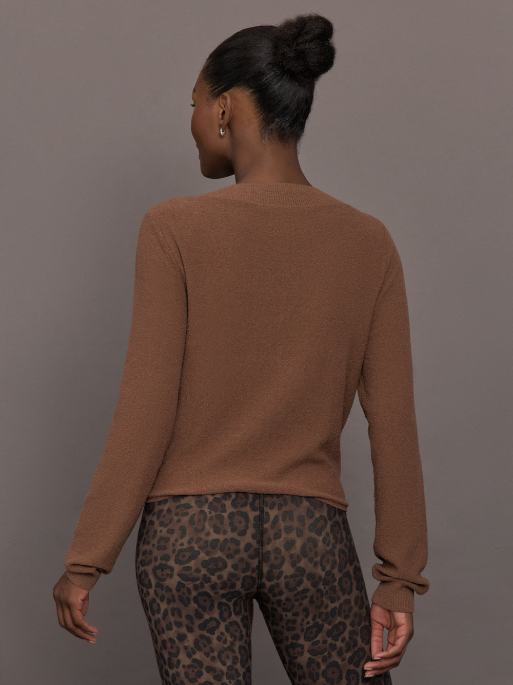 Model wearing a brown long-sleeve sweater with a knot detail 