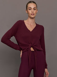 Model wearing a Fig colored long-sleeve top with knot detail