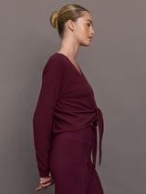 Model wearing a Fig colored long-sleeve top with knot detail