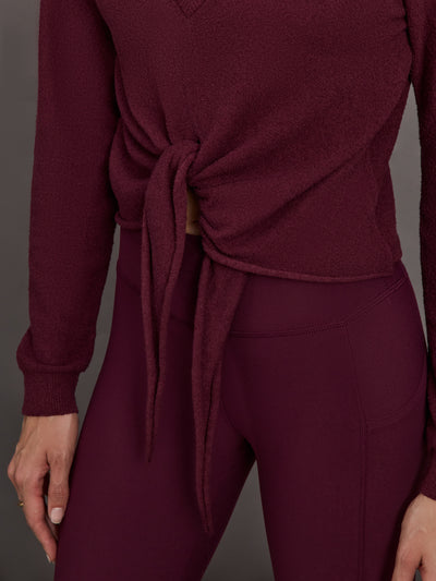 Model wearing a Fig colored long-sleeve top with knot detail